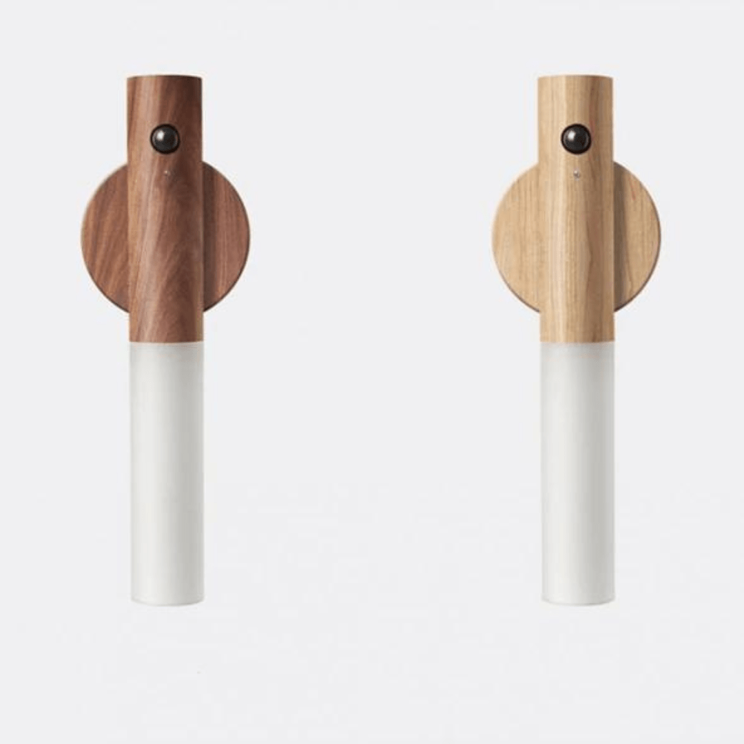 Two wooden salt and pepper shakers with white bodies on a light gray background