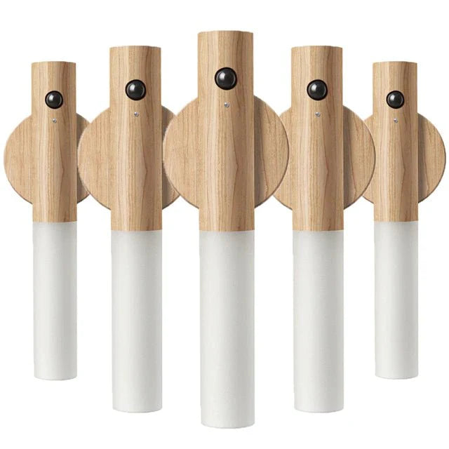 Set of five wooden wall hooks with white light on a white background