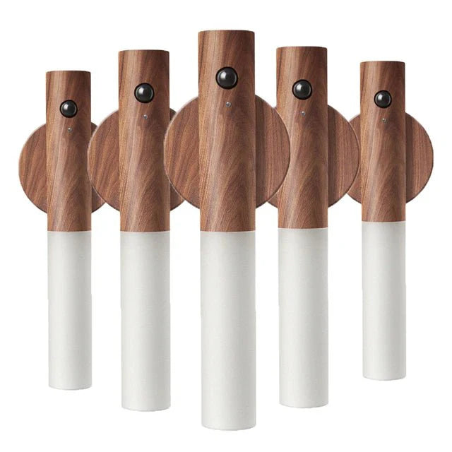 Set of five wooden wall hooks with white bases on a white background